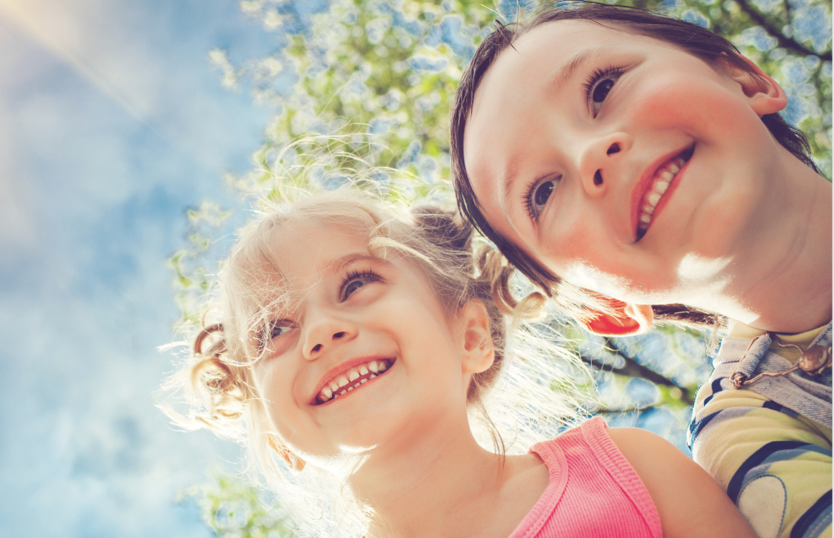 Two smiling children outside